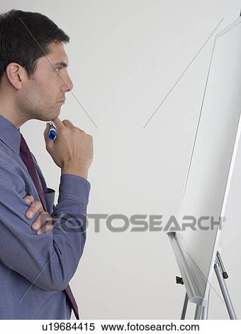 Stock Photography - Businessman contemplating what to write. Fotosearch