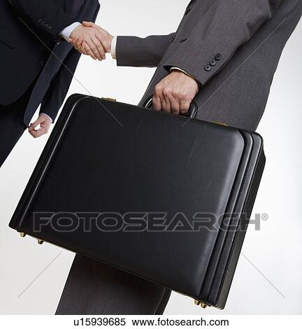 Stock Photography - Businessman with briefcase shaking hands. Fotosearch