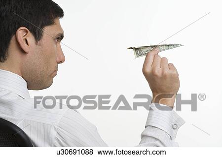 Businessman with paper bill airplane View Large Photo Image Stock Photo - Businessman with paper bill airplane. Fotosearch