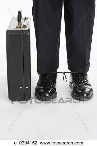 Businessman with shoelaces tied together View Large Photo Image Stock Image - Businessman with shoelaces tied together. Fotosearch