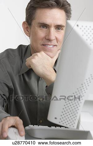 Stock Image - Businessman working at computer. Fotosearch