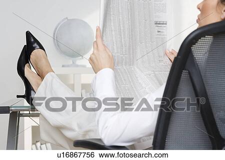 Businesswoman reading business page View Large Photo Image Stock Photograph - Businesswoman reading business page. Fotosearch