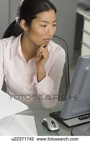 Stock Image - Businesswoman working at computer. Fotosearch
