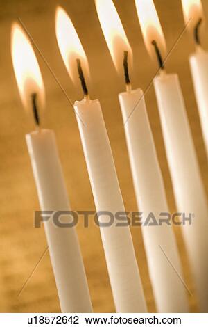 Stock Image - Candles burning in a menorah. Fotosearch