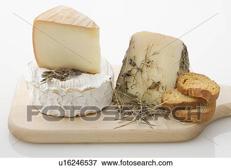 Stock Photo - Cheeses on cutting board. Fotosearch
