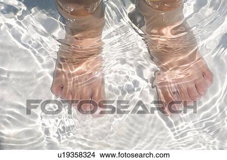 Child's feet standing in water View Large Photo Image Picture - Child's feet standing in water. Fotosearch