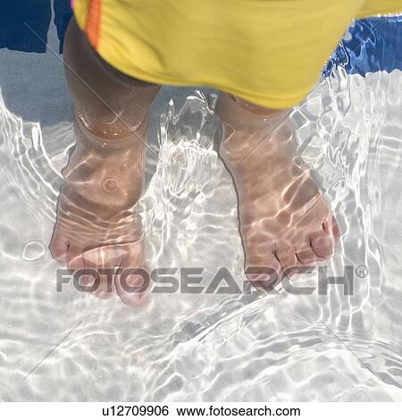 Stock Photograph - Child's feet standing in water. Fotosearch