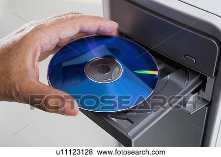 Stock Photo - Close up of cd being inserted in to cd rom drive. Fotosearch