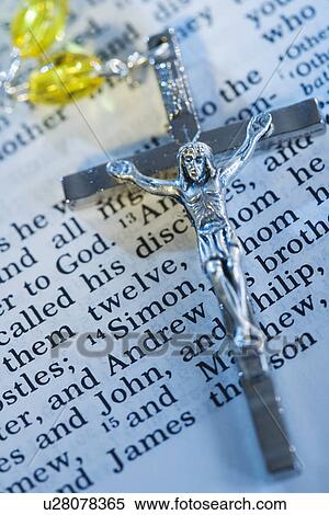 Stock Photography - Close up of crucifix with rosary on Bible. Fotosearch