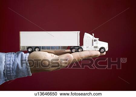 Stock Image - Close up of man's hand holding toy truck. Fotosearch