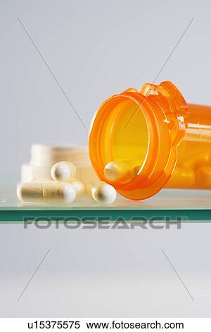 Stock Photography - Close up of pill bottle with pills spilled out. Fotosearch