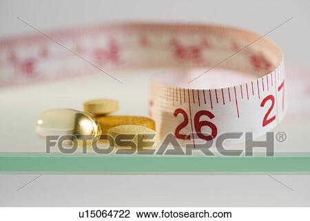Close up of pills and measuring tape View Large Photo Image Stock Image - Close up of pills and measuring tape. Fotosearch