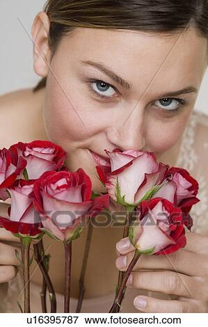Close up of woman smelling stemmed roses View Large Photo Image Stock Photo - Close up of woman smelling stemmed roses. Fotosearch