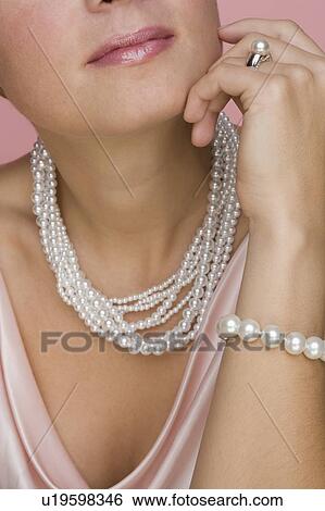 Stock Photograph - Close up of woman wearing pearls. Fotosearch