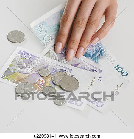 Stock Image - Close up studio shot of woman's hand and money. Fotosearch