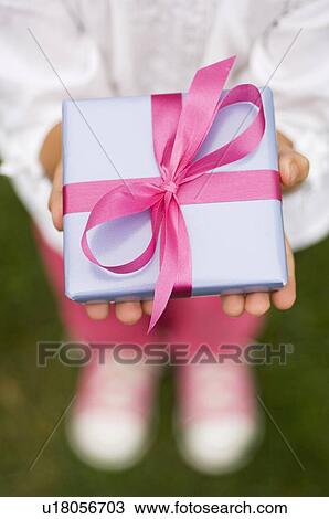 Stock Image - Closeup of a present in a childs hands. Fotosearch