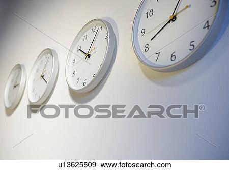 Stock Photo - Closeup of clocks telling different times. Fotosearch