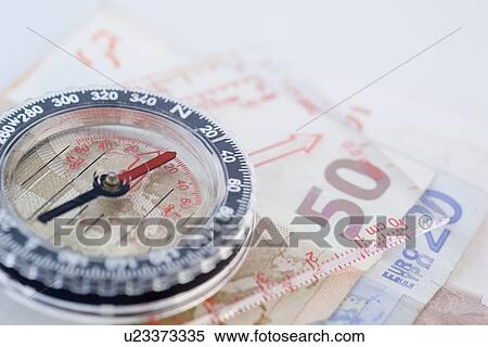 Closeup of compass with money View Large Photo Image Stock Photography - Closeup of compass with money. Fotosearch