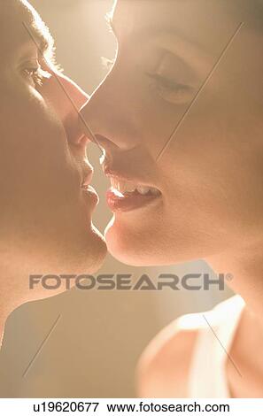 Stock Photo - Closeup of couple kissing in sunlight. Fotosearch
