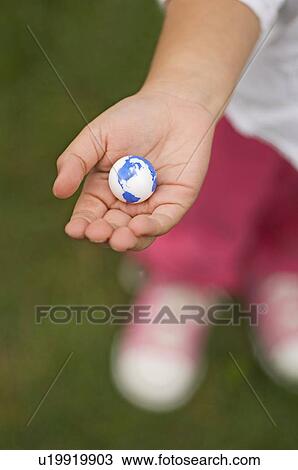 Stock Image - Closeup of earth in childs hand. Fotosearch