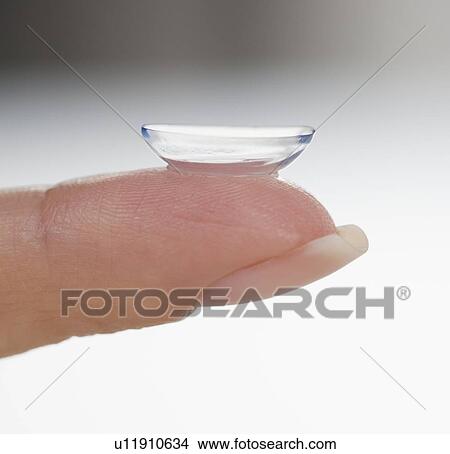 Picture - Closeup of finger with contact lens. Fotosearch