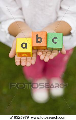 Stock Photo - Closeup of girl holding alphabet blocks. Fotosearch