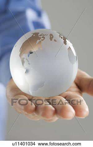 Picture - Closeup of glass globe in palm. Fotosearch