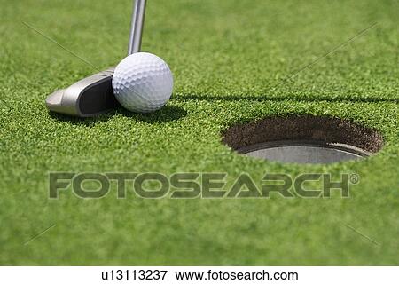 Closeup of golf ball and club near cup View Large Photo Image Stock Photo - Closeup of golf ball and club near cup. Fotosearch