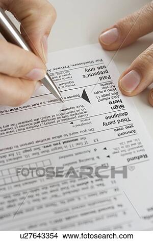 Closeup of hands signing tax form View Large Photo Image Picture - Closeup of hands signing tax form. Fotosearch