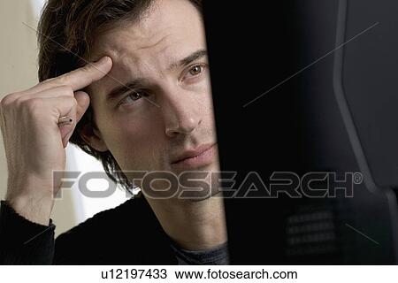 Stock Image - Closeup of man concentrating at computer. Fotosearch