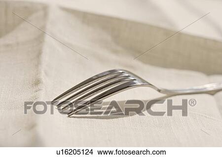 Picture - Closeup of metal fork on a napkin. Fotosearch
