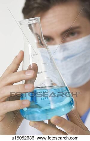Closeup of scientist examining blue liquid View Large Photo Image Stock Photograph - Closeup of scientist examining blue liquid. Fotosearch