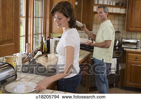 Couple drying dishes in kitchen View Large Photo Image Picture - Couple drying dishes in kitchen. Fotosearch