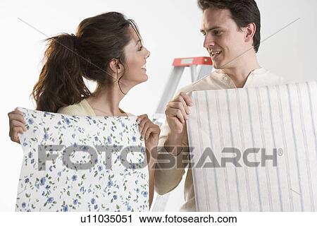 Couple hanging wallpaper at home View Large Photo Image Stock Image - Couple hanging wallpaper at home. Fotosearch