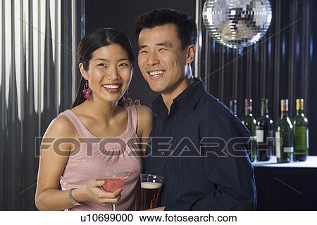 Stock Image - Couple having drinks in a bar. Fotosearch