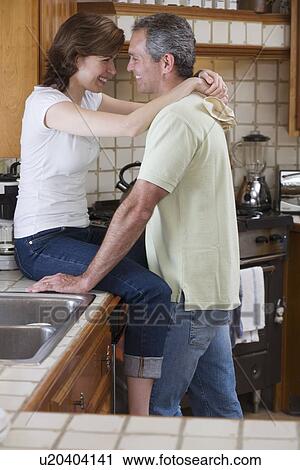Couple hugging in kitchen View Large Photo Image Stock Image - Couple hugging in kitchen. Fotosearch