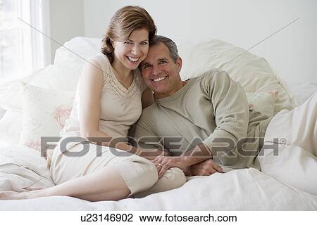 Stock Image - Couple hugging on bed. Fotosearch