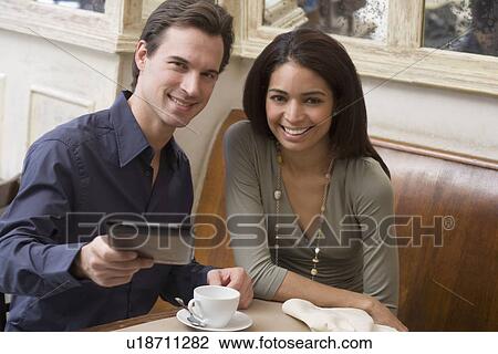Stock Image - Couple paying bill at restaurant. Fotosearch