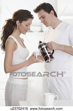 Stock Photograph - Couple pouring coffee from french press. Fotosearch