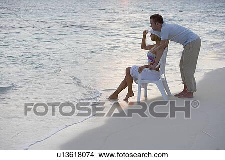 Picture - Couple relaxing at the beach. Fotosearch