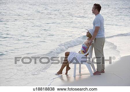 Stock Photo - Couple relaxing at the beach. Fotosearch