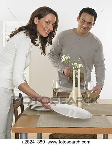 Stock Photo - Couple setting the table. Fotosearch