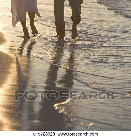 Stock Photo - Couple strolling on a beach. Fotosearch