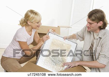 Stock Photo - Couple unpacking after moving. Fotosearch