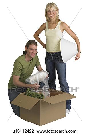 Couple unpacking box on moving day View Large Photo Image Stock Image - Couple unpacking box on moving day. Fotosearch