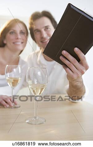 Couple with wine paying their bill View Large Photo Image Stock Photo - Couple with wine paying their bill. Fotosearch