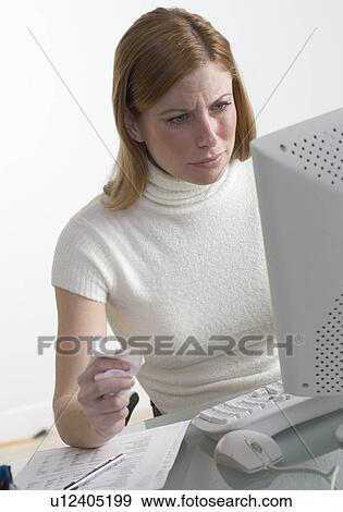Stock Photo - Distressed woman at desk with computer. Fotosearch
