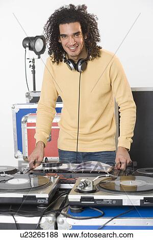 Stock Photo - DJ with his music mixing equipment. Fotosearch