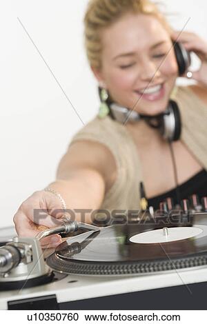 Stock Image - DJ working at music mixing board. Fotosearch