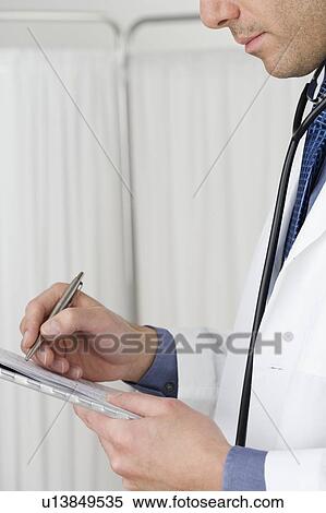 Stock Photography - Doctor writing on chart. Fotosearch